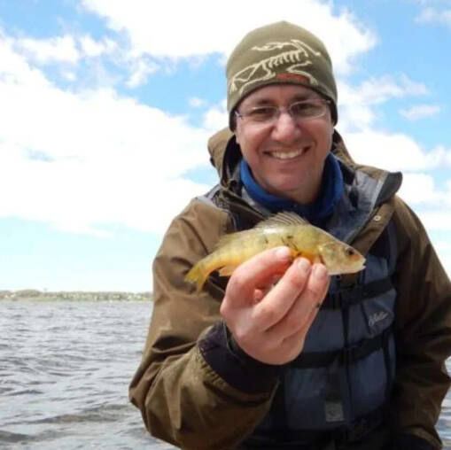 Dr. Carl Ruetz displays a fish for the camera.